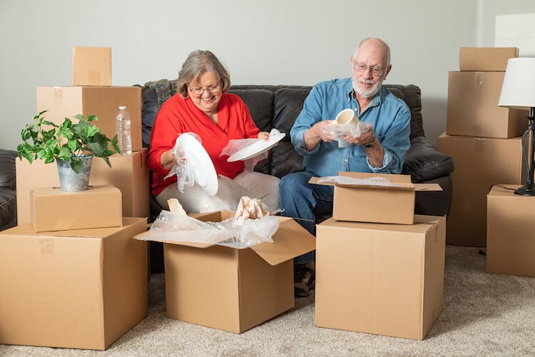 A senior couple packs for a move