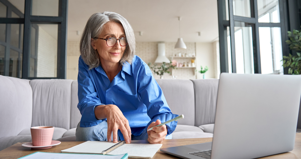 A senior woman works on her laptop