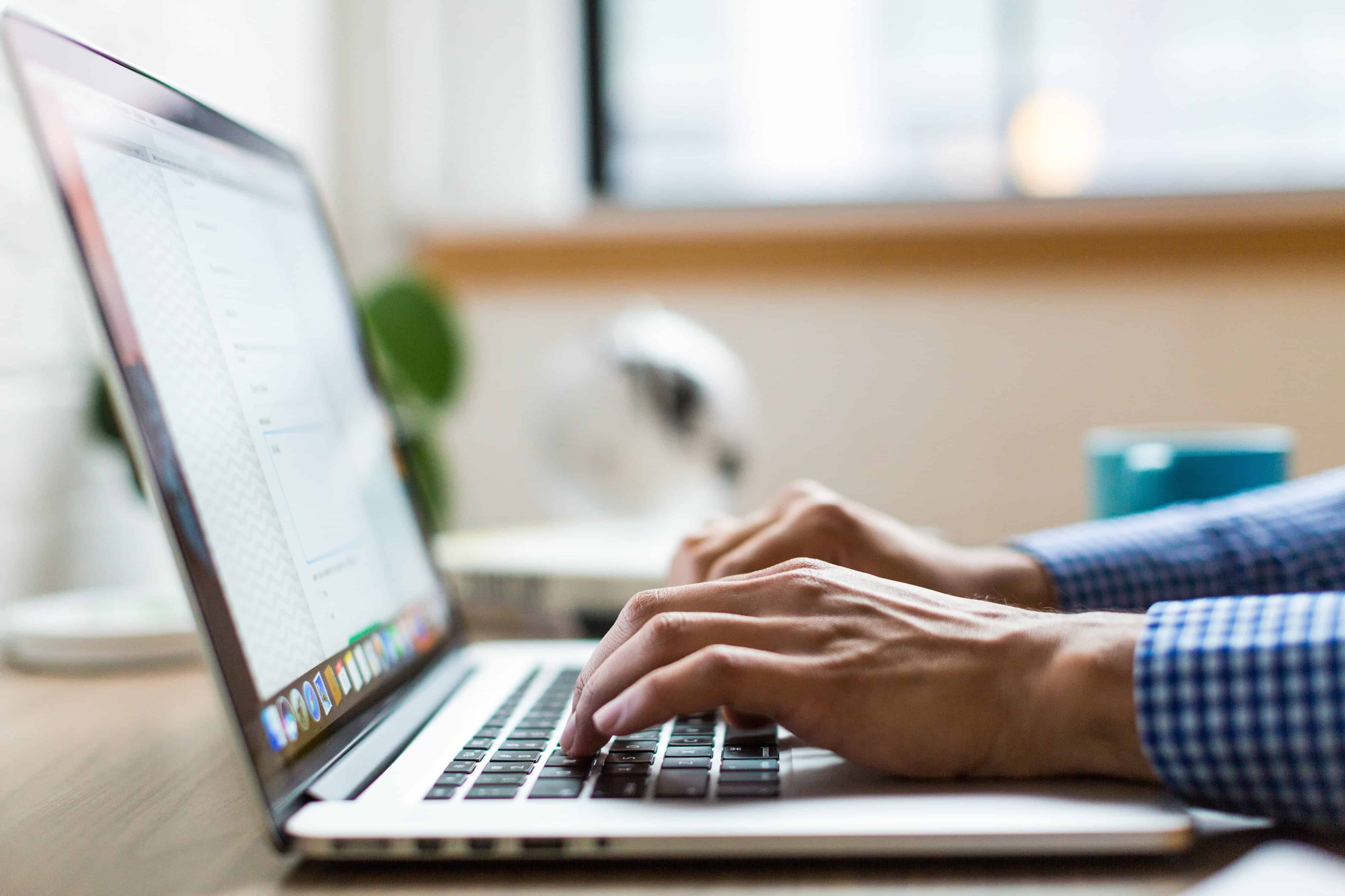 Male hands typing on a laptop keyboard