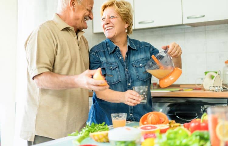 Happy senior couple prepares fruits and vegetables for eye health.