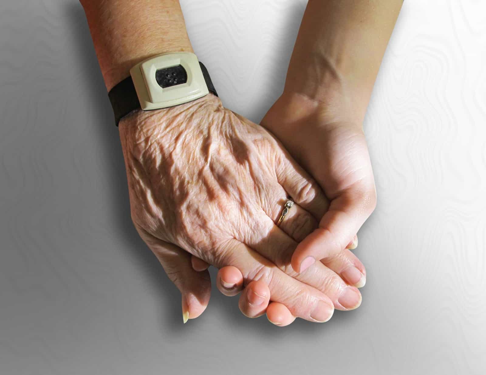 A younger person's hand offering a help to a senior