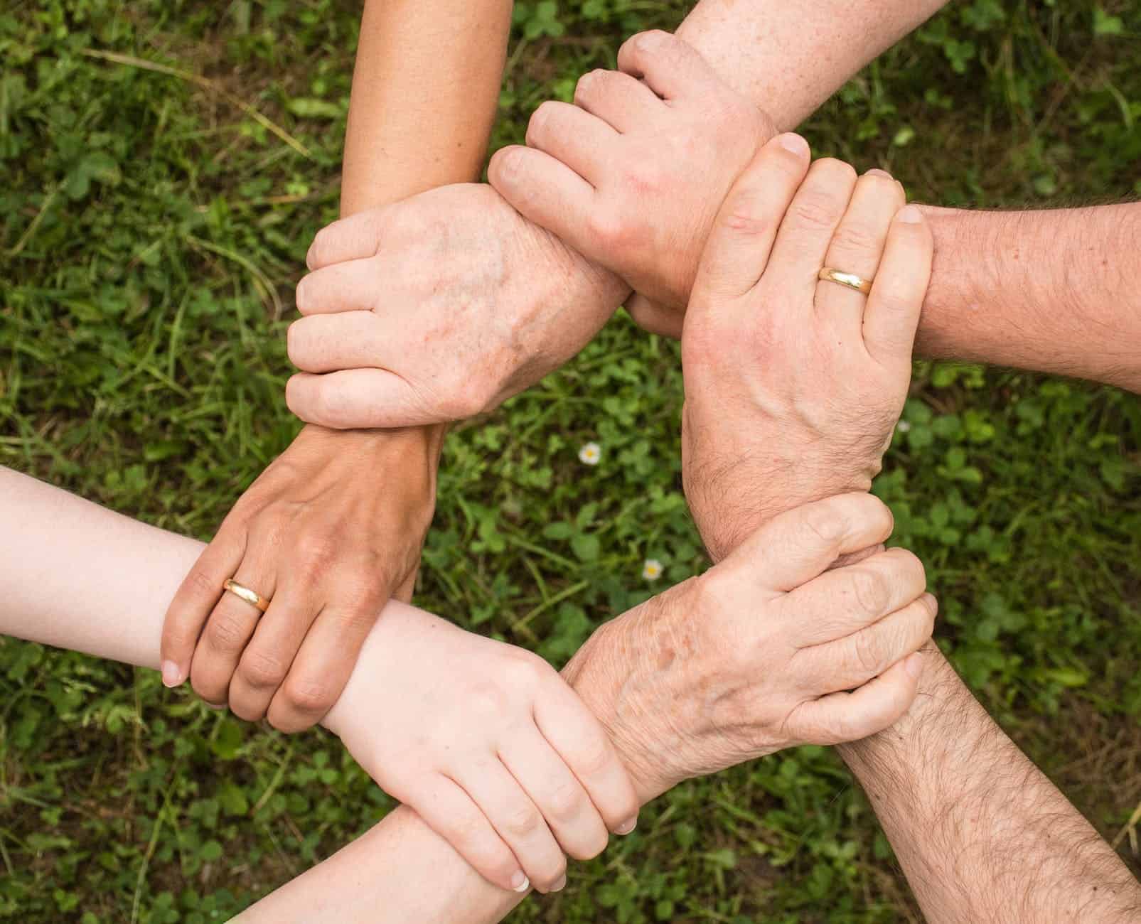 Volunteer group holding one another's wrists to form a circle