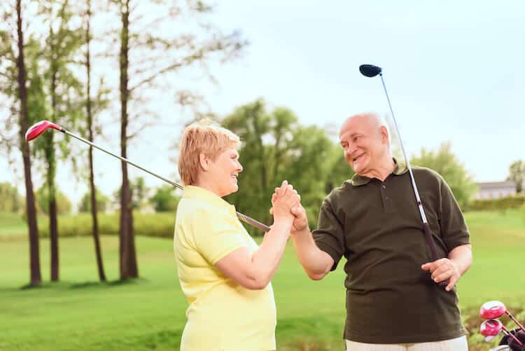 Senior couple celebrates during a round of golf.