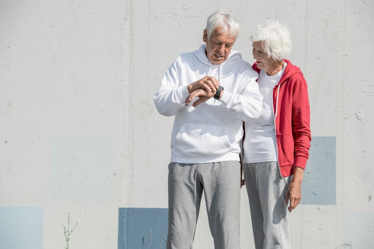 Senior couple reviews a smart watch.