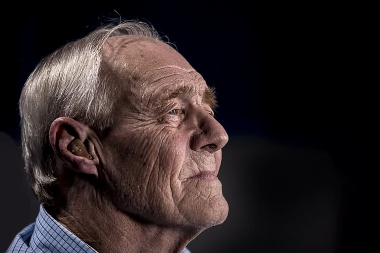 An elderly male with a sad expression on their face