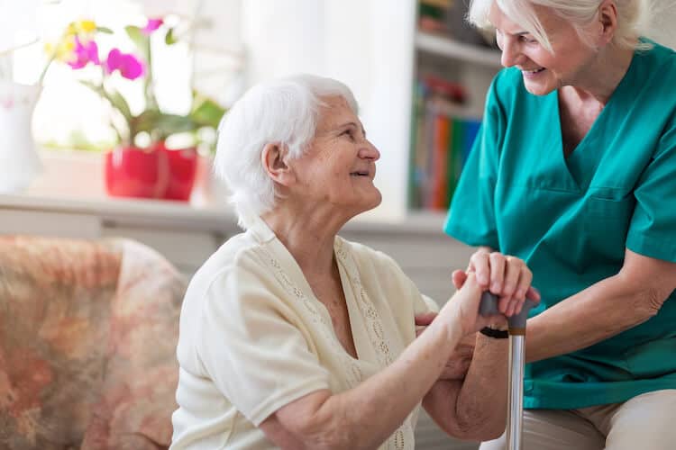 A smiling senior woman with her caregiver at an assisted living community.