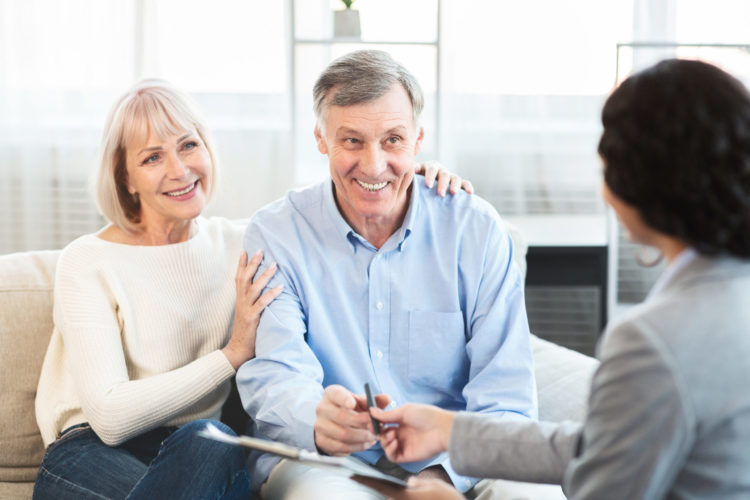 Happy senior couple consulting with a real estate agent.