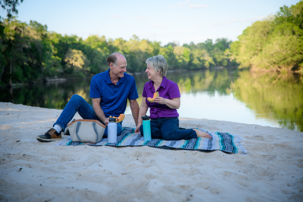 Couple having a picnic on a lake beach