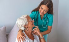 A smiling senior woman with her nurse at home.