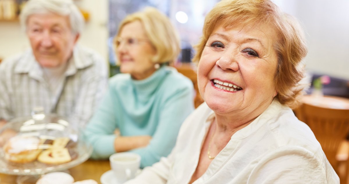 A senior woman enjoys breakfast with friends